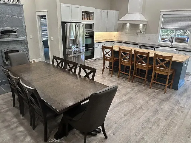 a dining table with chairs and kitchen view