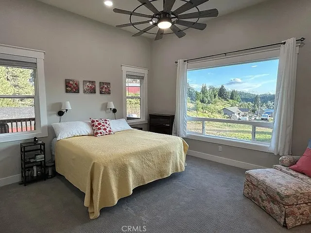a bedroom with a bed and a large window