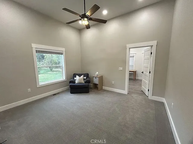 en empty room with windows and ceiling fan