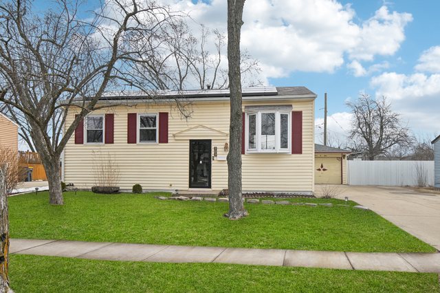 a front view of a house with a yard and trees