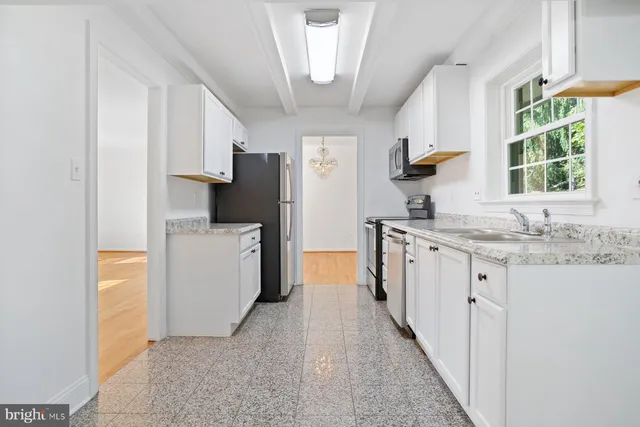 a kitchen with granite countertop a sink stove and refrigerator