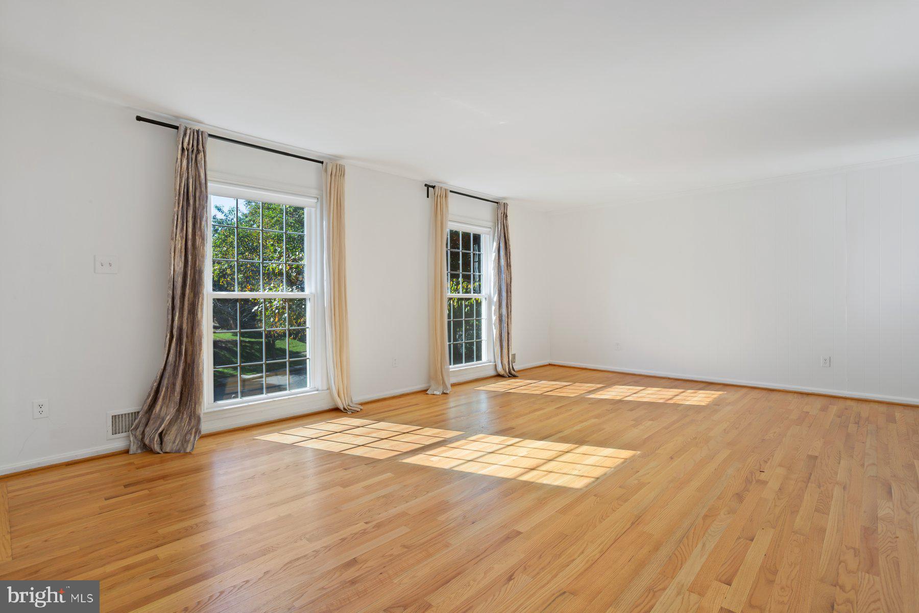 1242 Derbyshire Road Potomac, MD 20854 - Photo 22 of 40 a view of an empty room with wooden floor and a window