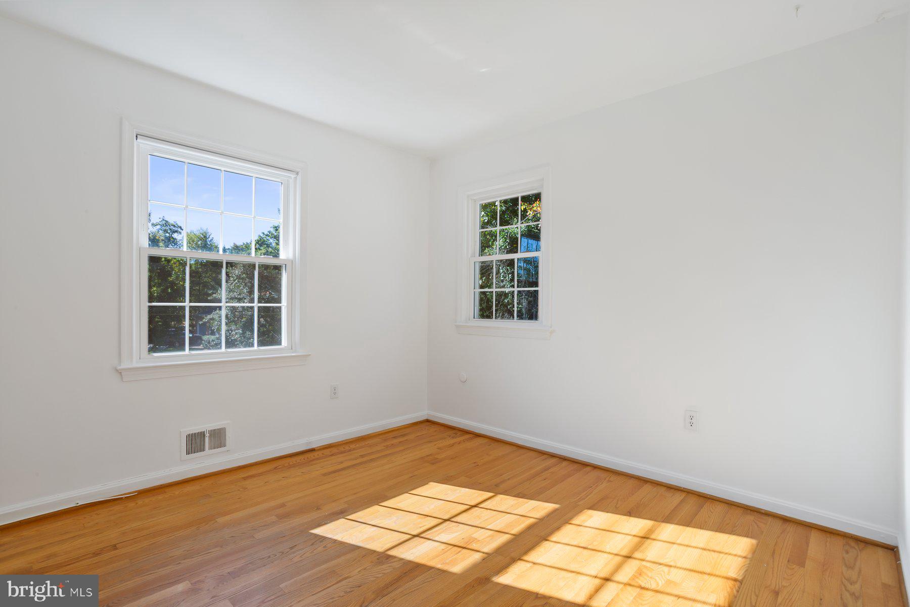1242 Derbyshire Road Potomac, MD 20854 - Photo 25 of 40 a view of an empty room with wooden floor and a window