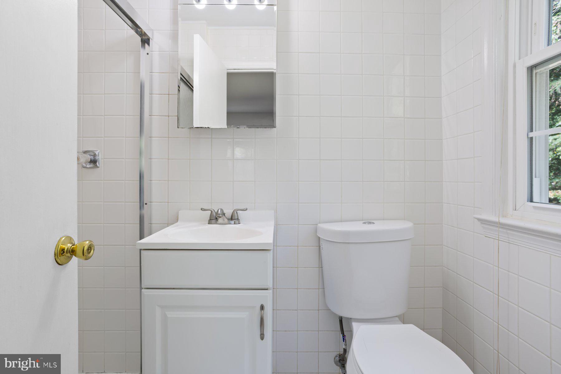 1242 Derbyshire Road Potomac, MD 20854 - Photo 33 of 40 a bathroom with a toilet a sink and a mirror
