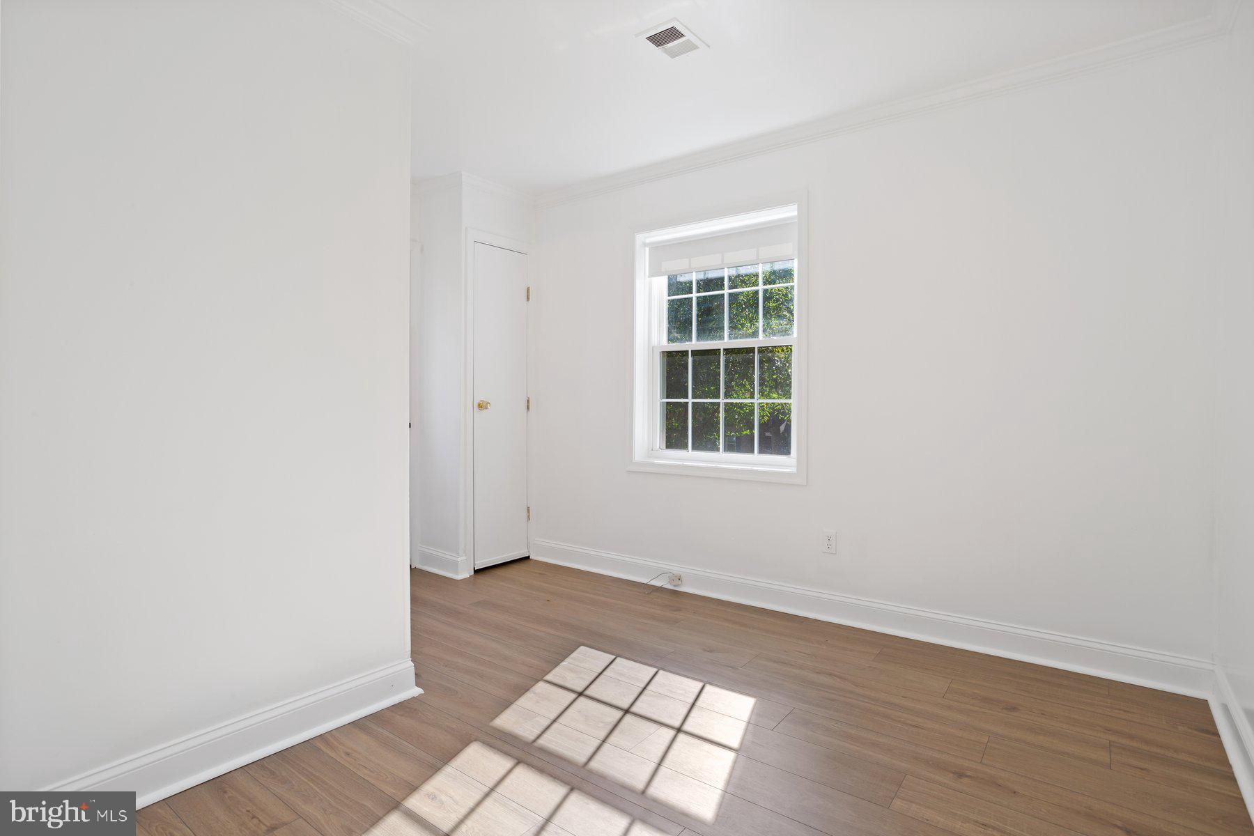 1242 Derbyshire Road Potomac, MD 20854 - Photo 35 of 40 an empty room with wooden floor and windows