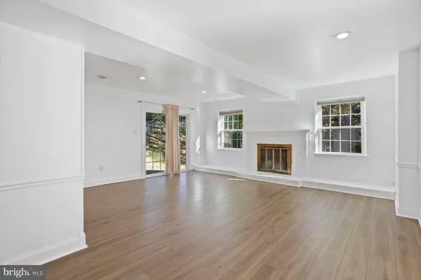 an empty room with wooden floor and fireplace
