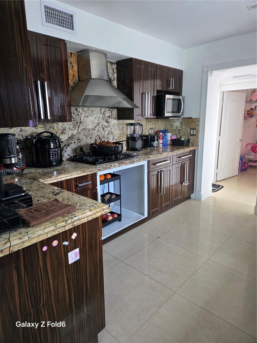 234 East 44th Street Hialeah, FL 33013 - Photo 6 of 14 a kitchen with stainless steel appliances granite countertop a stove a sink and a microwave