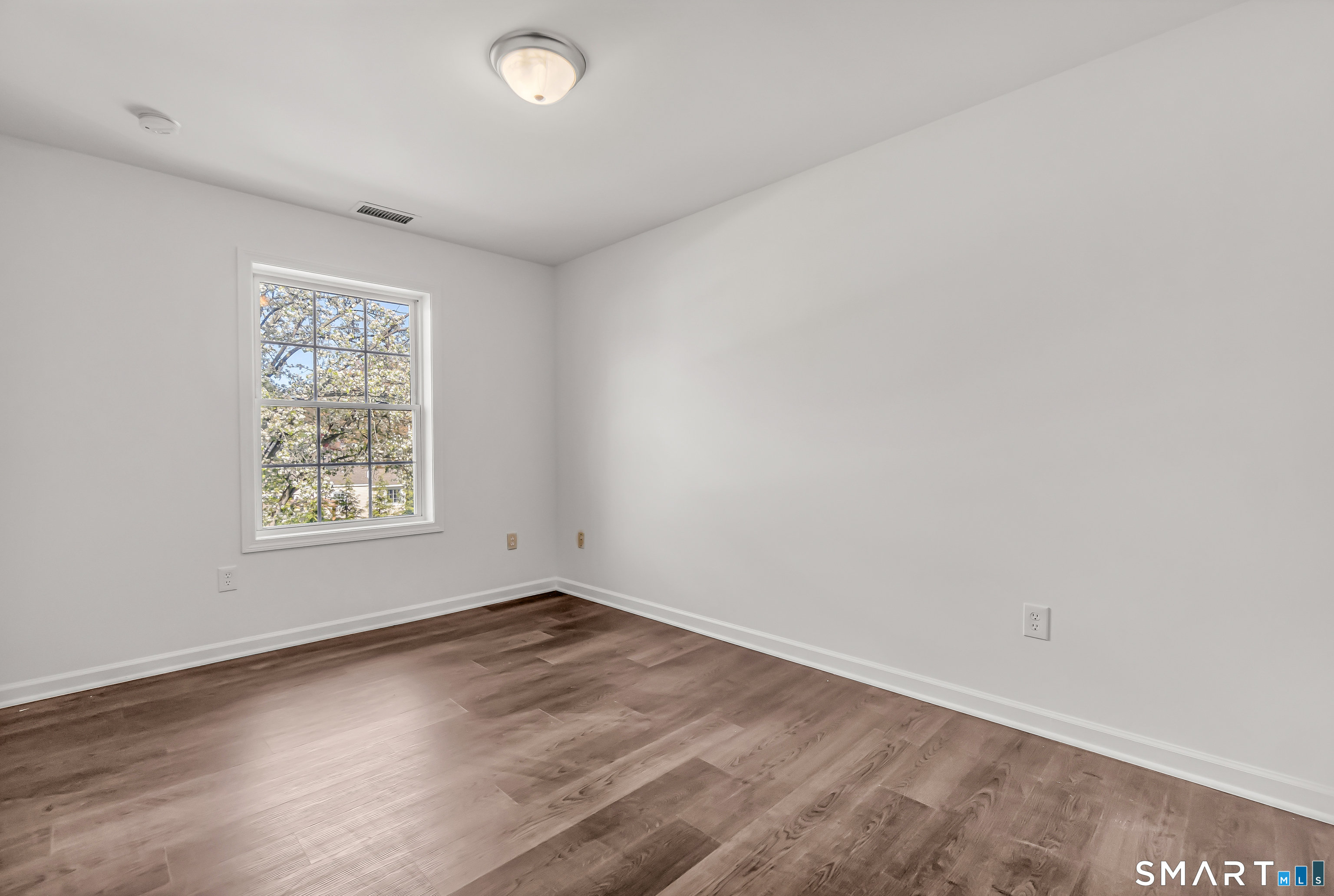 1770 Stratfield Road Fairfield, CT 06825 - Photo 21 of 40 an empty room with wooden floor and windows
