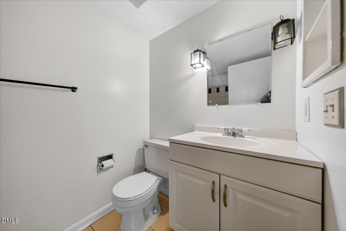 3088 Colony Road, Unit 3088D Durham, NC 27705 - Photo 14 of 25 a bathroom with a toilet sink and mirror
