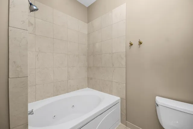 a bathroom with a white toilet and a bathtub