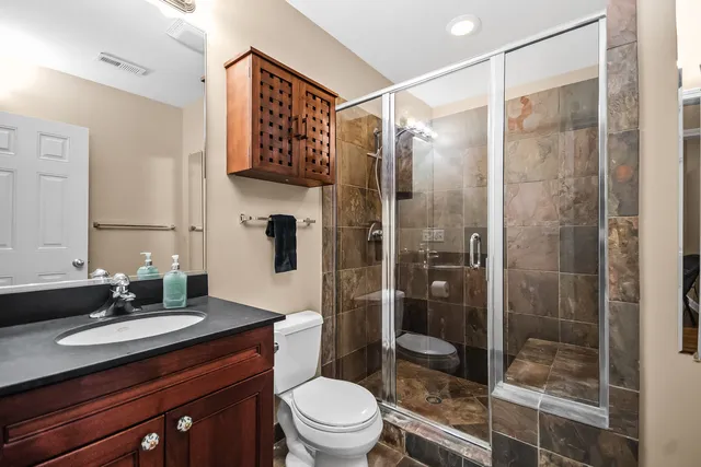 a bathroom with a granite countertop sink toilet and shower