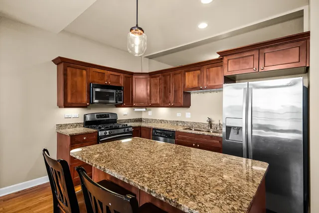 a kitchen with stainless steel appliances granite countertop a sink refrigerator and microwave
