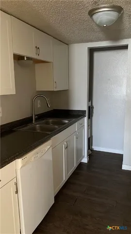 a kitchen with granite countertop a sink and a stove