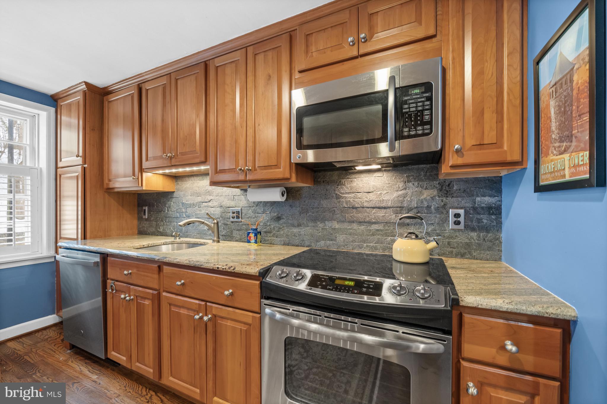 55 Ivy Road Wilmington, DE 19806 - Photo 16 of 38 a kitchen with stainless steel appliances granite countertop a stove a sink and a microwave