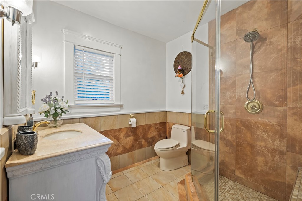790 North El Molino Avenue Pasadena, CA 91104 - Photo 20 of 34 a bathroom with a granite countertop sink a toilet a mirror and shower