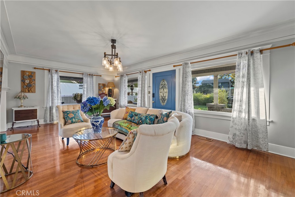 790 North El Molino Avenue Pasadena, CA 91104 - Photo 7 of 34 a dining room with wooden floor a chandelier a glass table and chairs