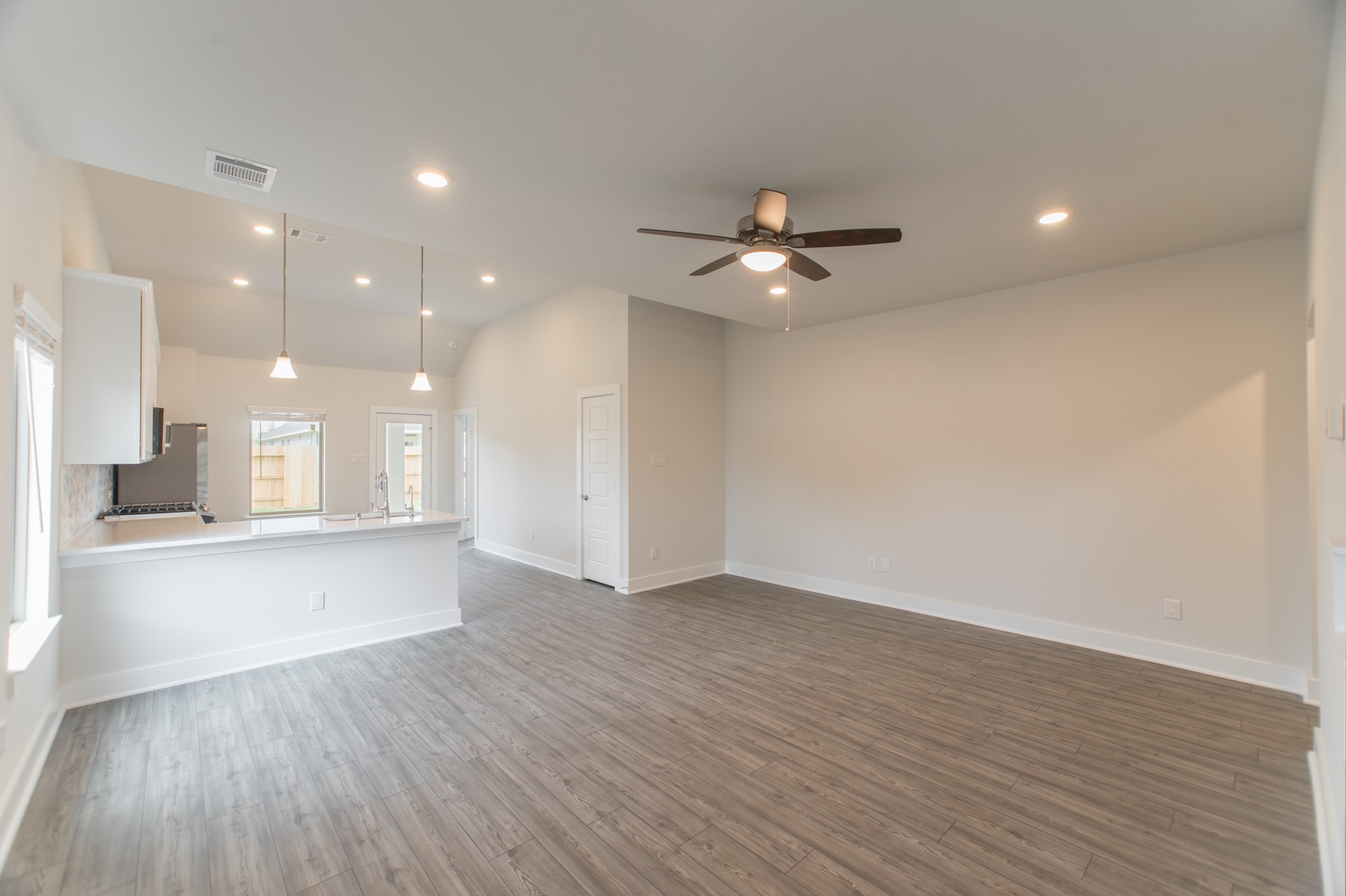 10539 Preserve Way Conroe, TX 77385 - Photo 4 of 31 a view of an empty room with wooden floor and a kitchen