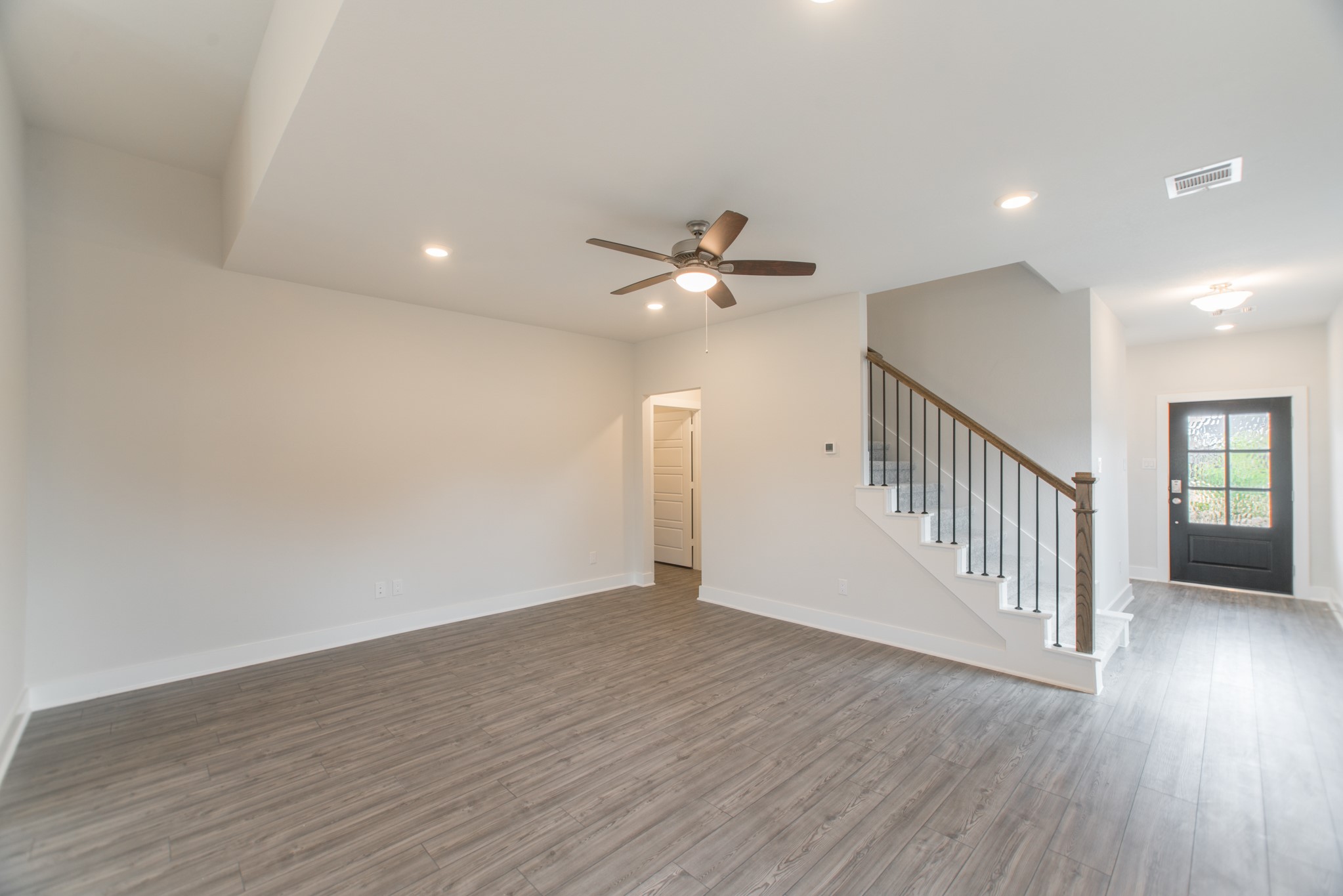 10539 Preserve Way Conroe, TX 77385 - Photo 5 of 31 a view of an empty room with wooden floor and a ceiling fan