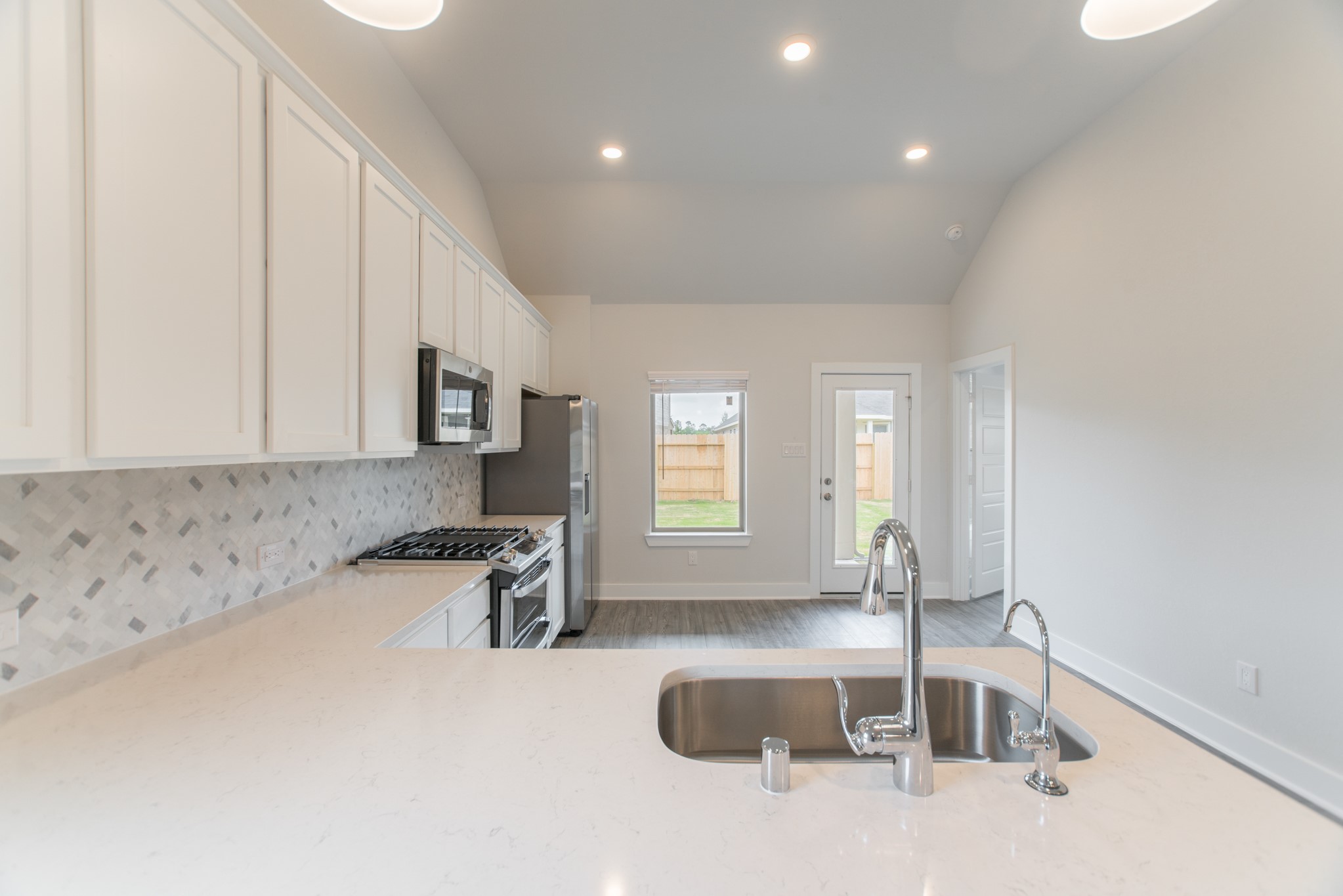 10539 Preserve Way Conroe, TX 77385 - Photo 9 of 31 a kitchen with granite countertop a sink and a stove top oven