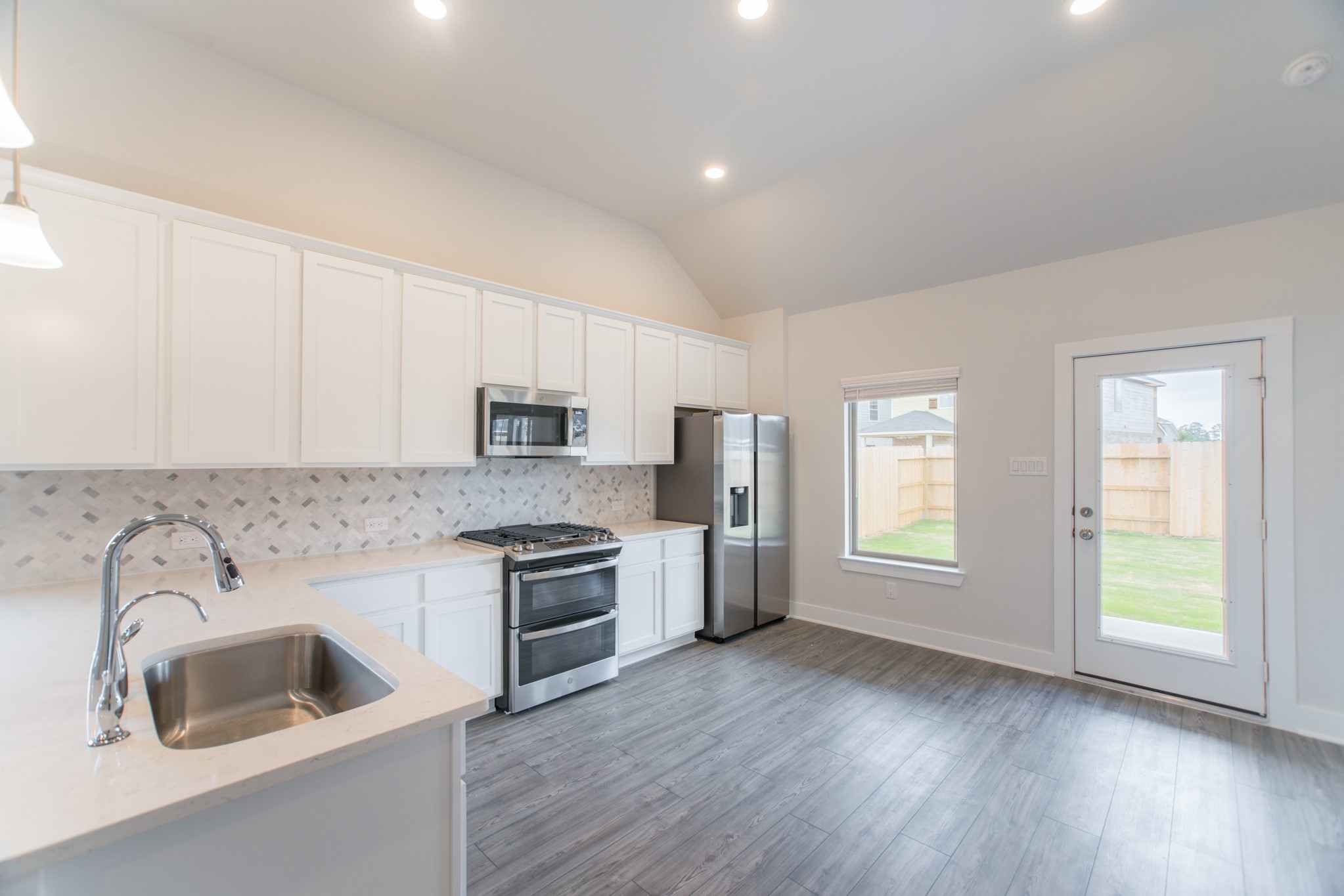 10539 Preserve Way Conroe, TX 77385 - Photo 10 of 31 a kitchen with a sink wooden floor and stainless steel appliances