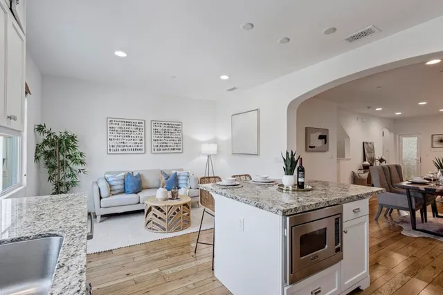 a kitchen with stainless steel appliances granite countertop a stove a sink and a white cabinets