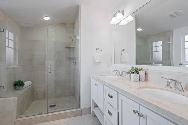 a bathroom with a shower sink and mirror