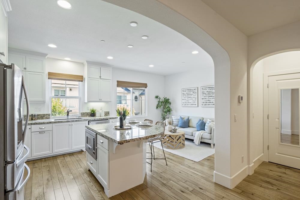 47236 Cavanaugh Common Fremont, CA 94539 - Photo 7 of 52 a kitchen with stainless steel appliances kitchen island granite countertop a stove refrigerator and cabinets