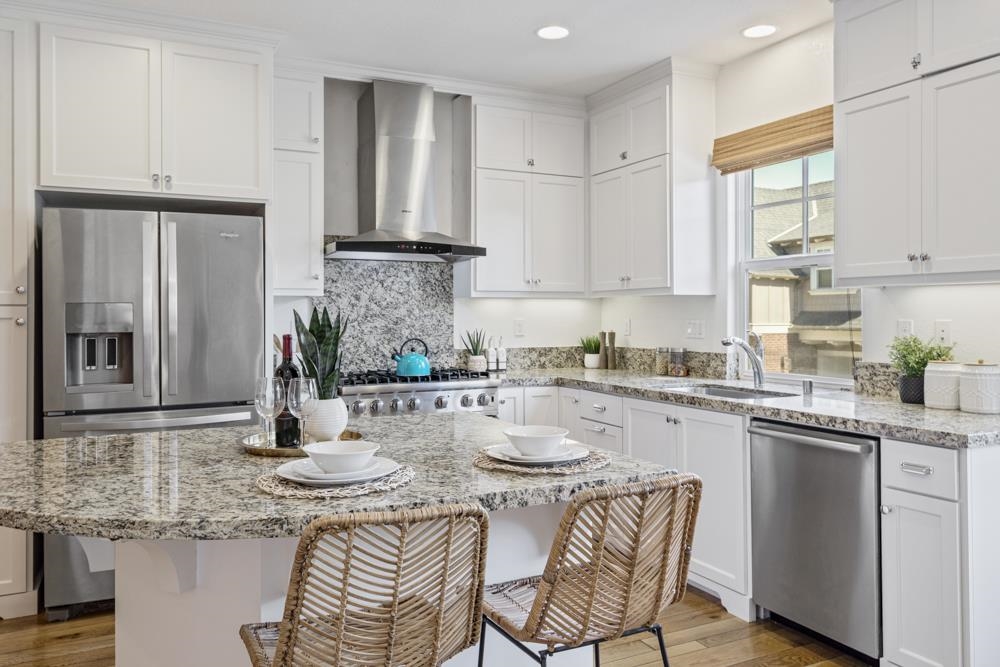 47236 Cavanaugh Common Fremont, CA 94539 - Photo 10 of 52 a kitchen with stainless steel appliances granite countertop a kitchen island a stove a table and chairs in it