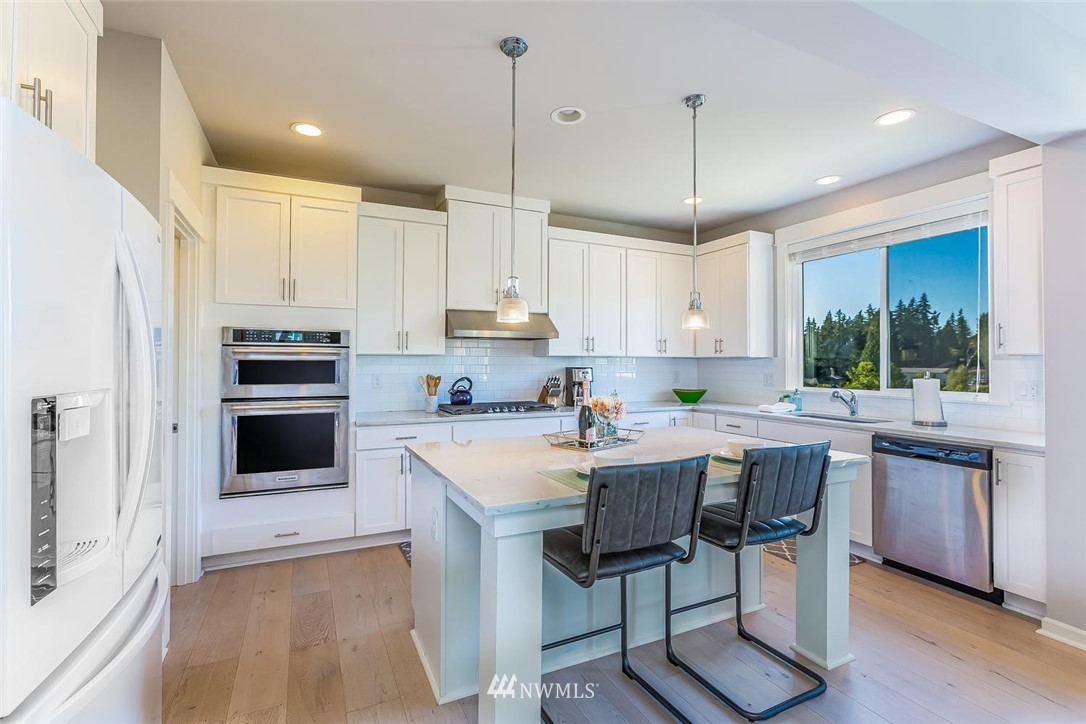 5638 Northeast 9th Street Renton, WA 98059 - Photo 4 of 40 a kitchen with kitchen island granite countertop a stove a sink a microwave a center island and cabinets