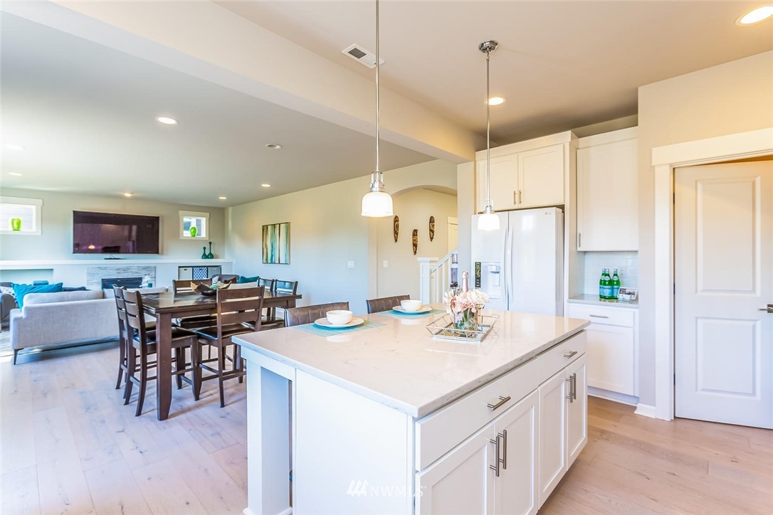 5638 Northeast 9th Street Renton, WA 98059 - Photo 9 of 40 a kitchen with a table a refrigerator a dining table and chairs