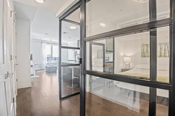 a view of a hallway view with wooden floor and dining room with chandelier