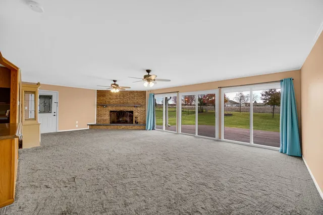 a view of an empty room with a fireplace and a window
