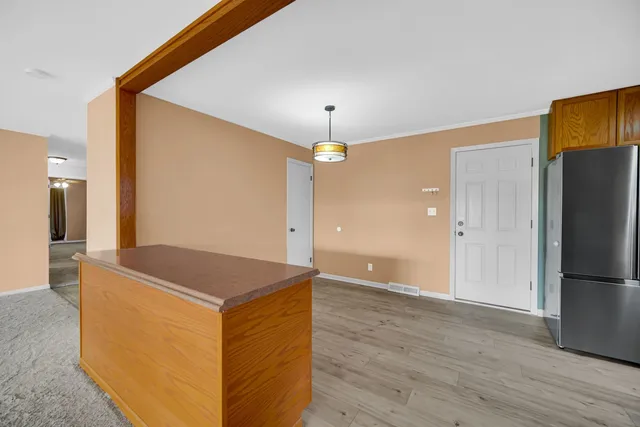 a kitchen view with granite countertop a refrigerator and a sink