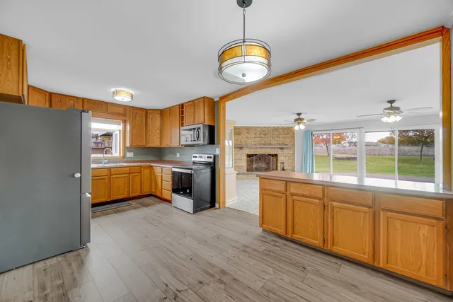 a large kitchen with stainless steel appliances granite countertop a stove and cabinets