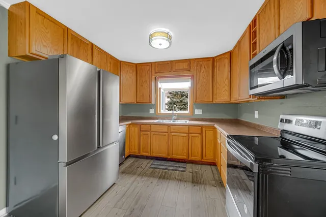 a kitchen with stainless steel appliances granite countertop a refrigerator a stove top oven a sink and dishwasher
