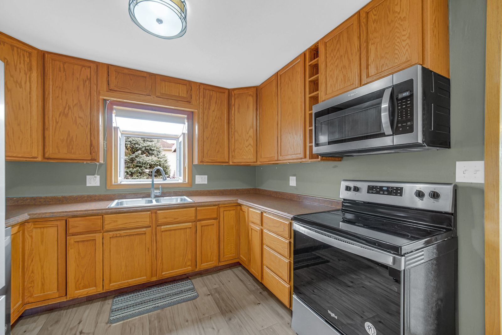 7427 McCurry Road Roscoe, IL 61073 - Photo 10 of 23 a kitchen with stainless steel appliances a stove a sink microwave and cabinets