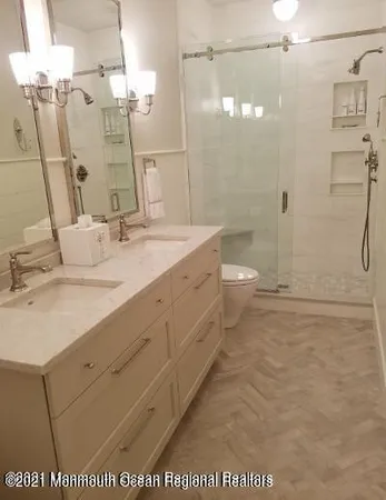 a bathroom with a granite countertop sink a toilet and shower