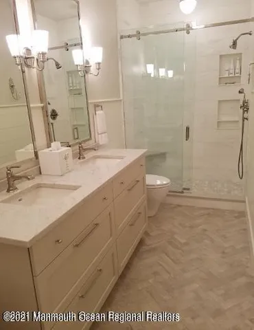 a bathroom with a granite countertop sink a toilet and shower