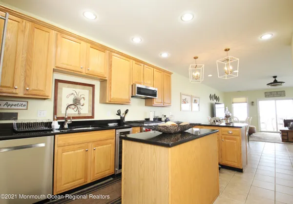 a kitchen with stainless steel appliances granite countertop a sink a stove and cabinets
