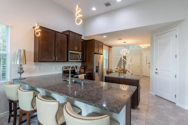 a kitchen with a table chairs sink and cabinets