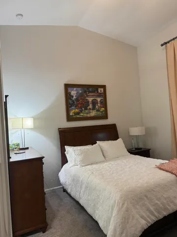 a bedroom with a bed and a lamp