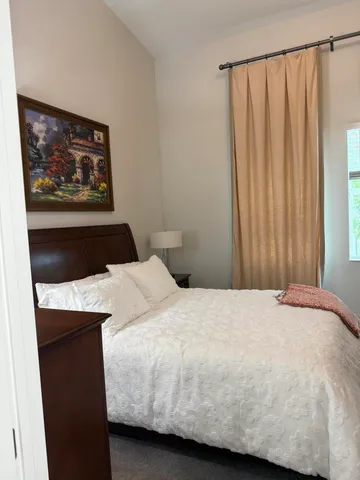 a bedroom with a bed and a painting on the wall