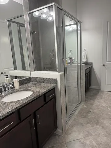 a bathroom with a granite countertop sink and a mirror