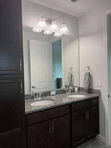 a bathroom with a granite countertop sink a large mirror and vanity