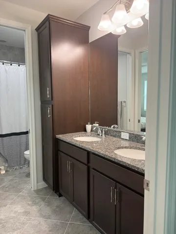 a bathroom with a granite countertop sink and a mirror