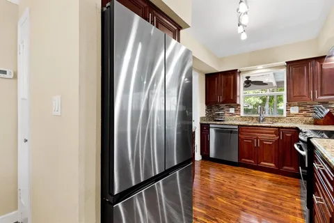 a kitchen with stainless steel appliances granite countertop a refrigerator sink and cabinets