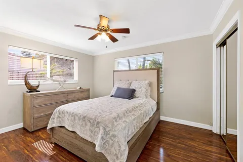 a bedroom with a bed and wooden floor