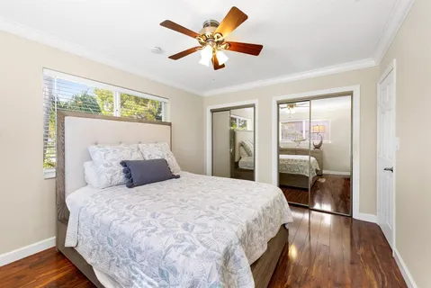 a bedroom with a bed and wooden floor