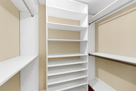 a view of walk in closet with empty racks