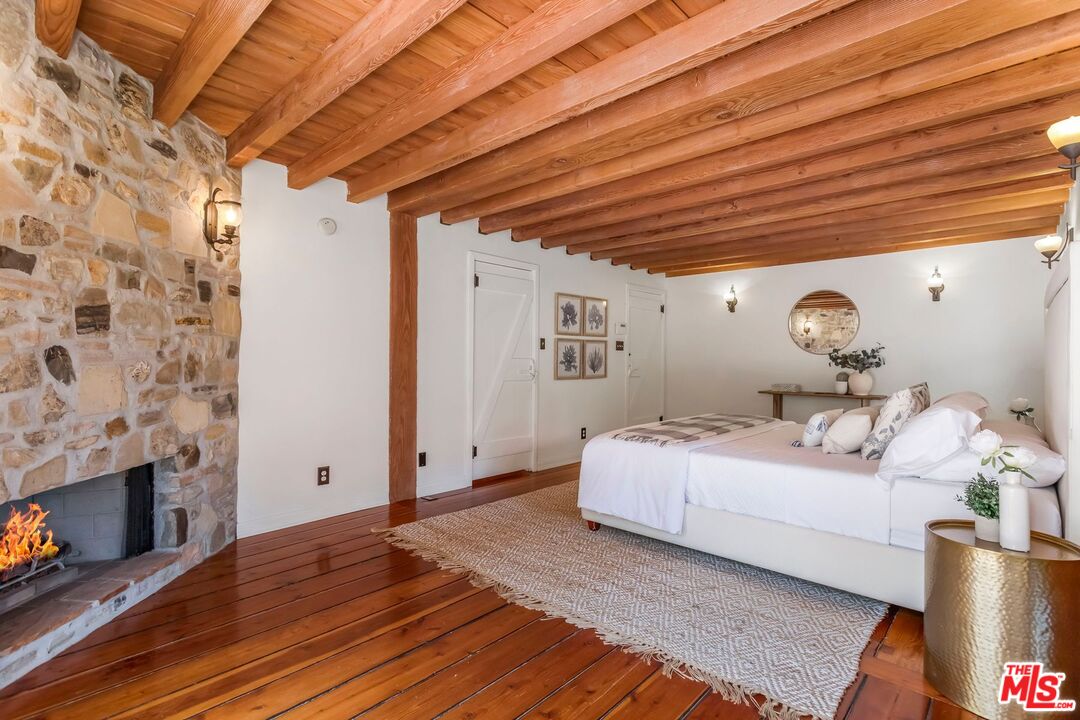 3940 Davana Road Sherman Oaks, CA 91423 - Photo 34 of 60 a spacious bedroom with a bed and a fireplace
